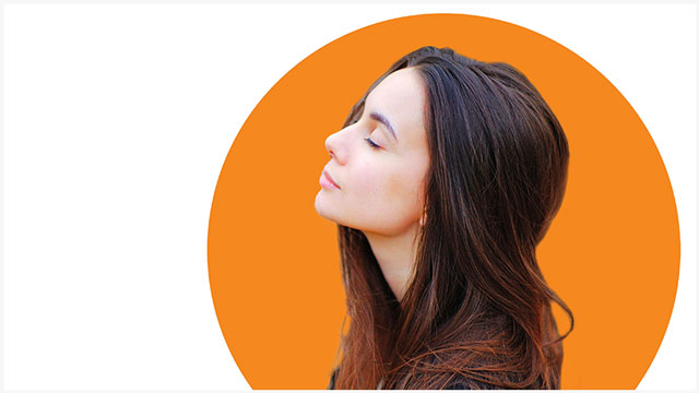 woman looking up with eyes closed with orange graphic behind her