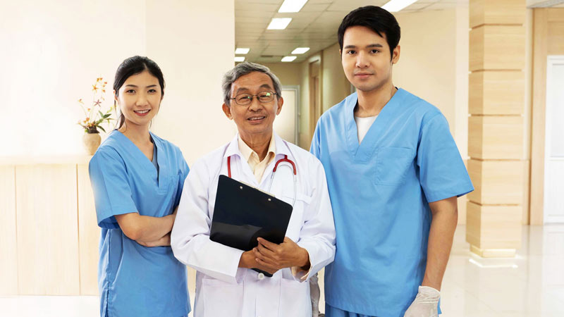 Three healthcare professionals standing in hospital hall