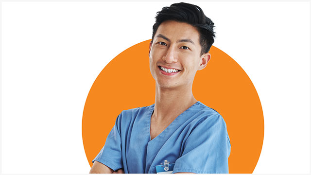 young male physician in scrubs with crossed arms smiling