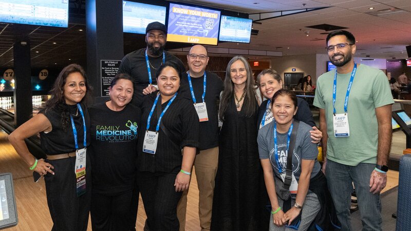 Smiling attendees at a bowling alley for a networking reception