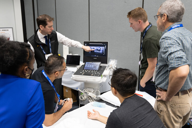Five attendees with male speaker performing a procedure in class