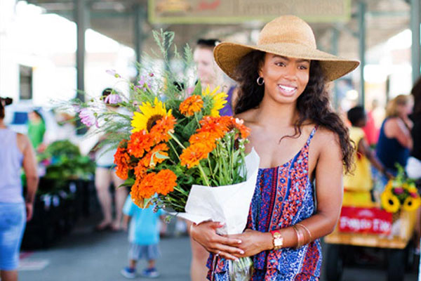 Woman at an outdoor market holding fresh flowers