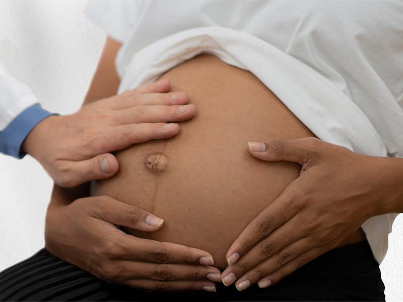 Pregnant woman showing belly with hands on belly