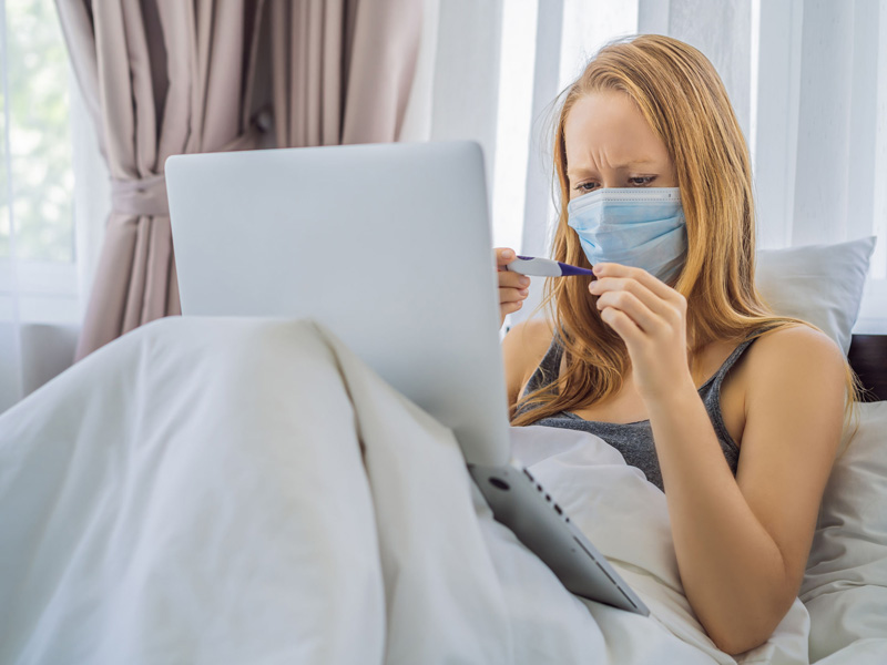 woman in bed doing online doc visit