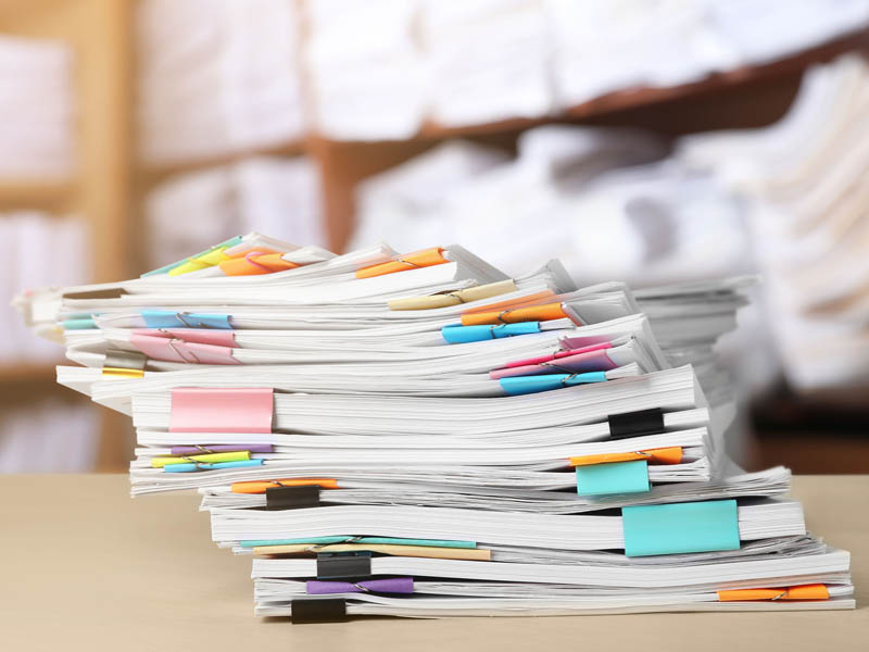 stack of documents with binder clips