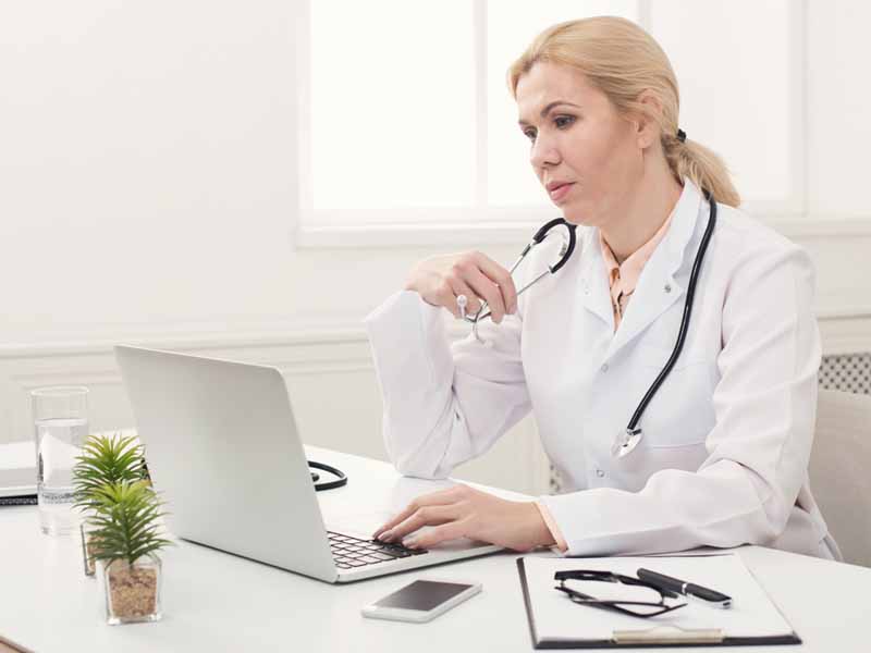 female physician using laptop