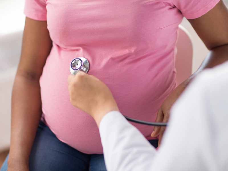 physician examining pregnant woman