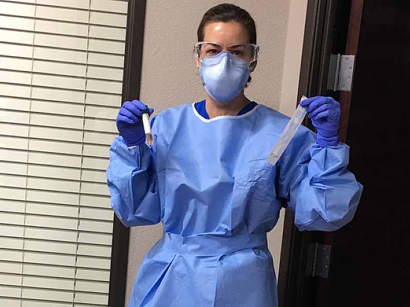 Gina Tobalina, M.D., dons the personal protective equipment she used when testing for COVID-19 in person before her office went virtual.