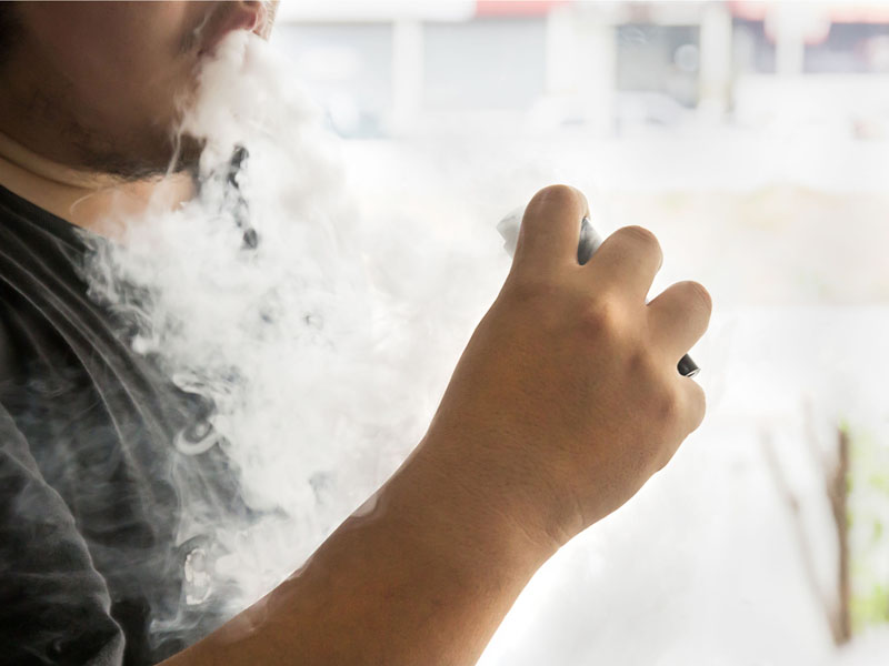 young man smoking an e-cigarette