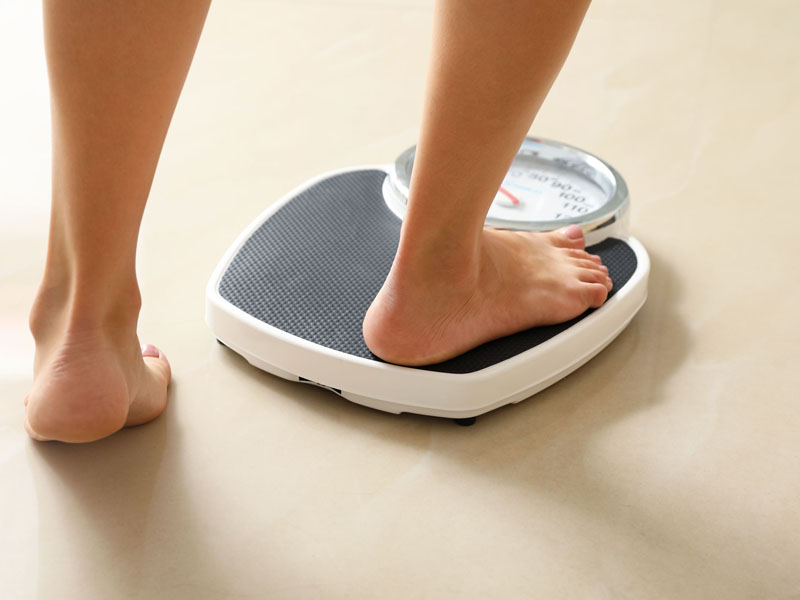 person stepping on scale to be weighed