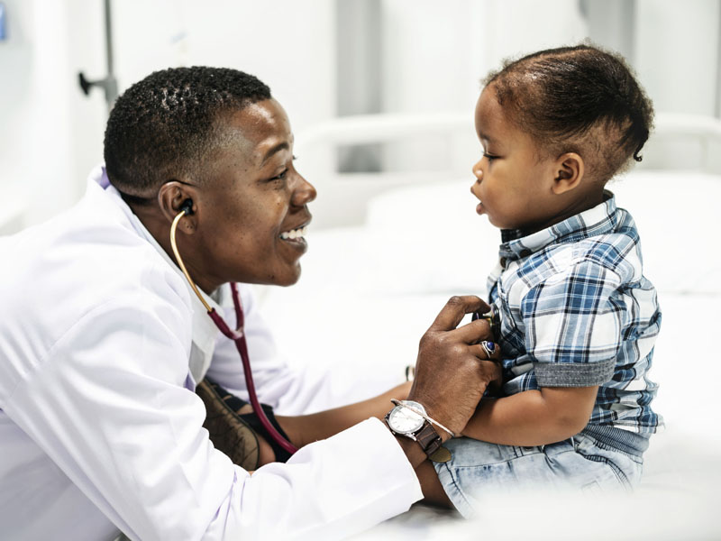 smiling physician examining young patient