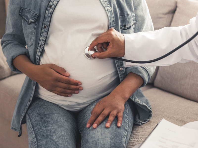 physician examining young pregnant woman