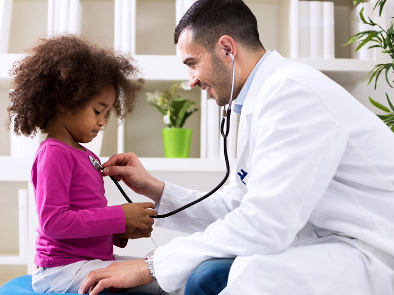 physician examining young girl with stethoscope