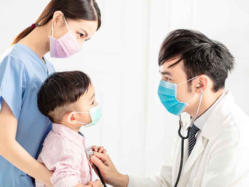 Physician with stethoscope examining child