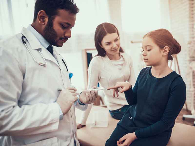 Physician checking young patient's blood sugar