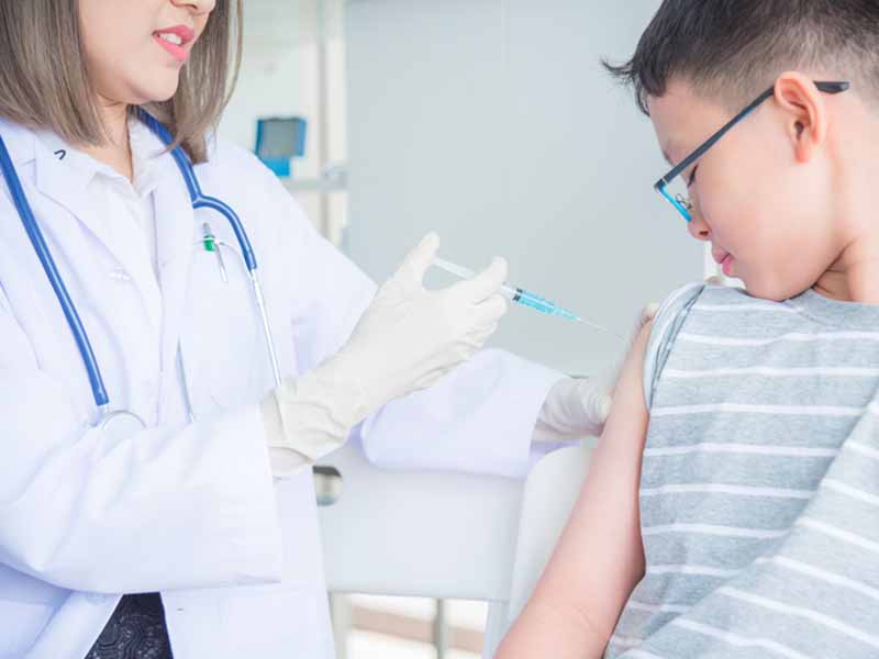 A doctor vaccinating a boy in clinic