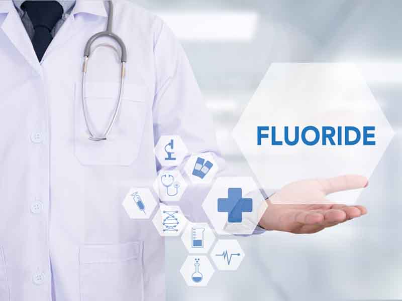 The word "Fluoride" above physician's hand