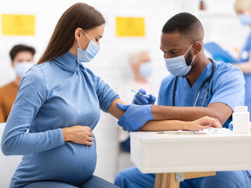 physician administering vaccine to pregnant woman