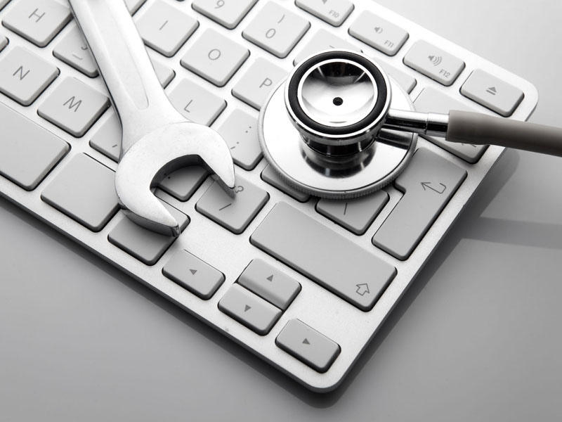 wrench and stethoscope on keyboard