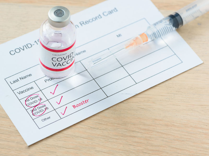 COVID-19 vaccine card and syringes