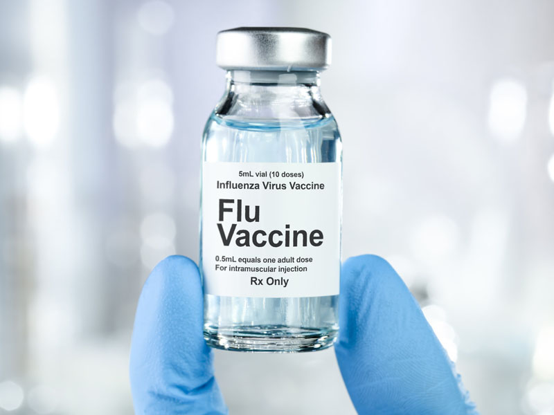 physician holding flu vaccine vial
