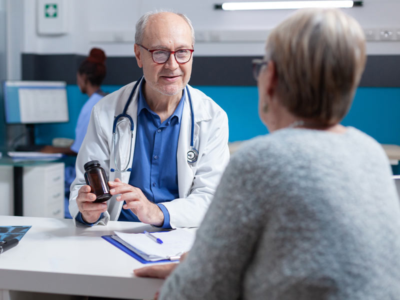 Older physician talking with patient