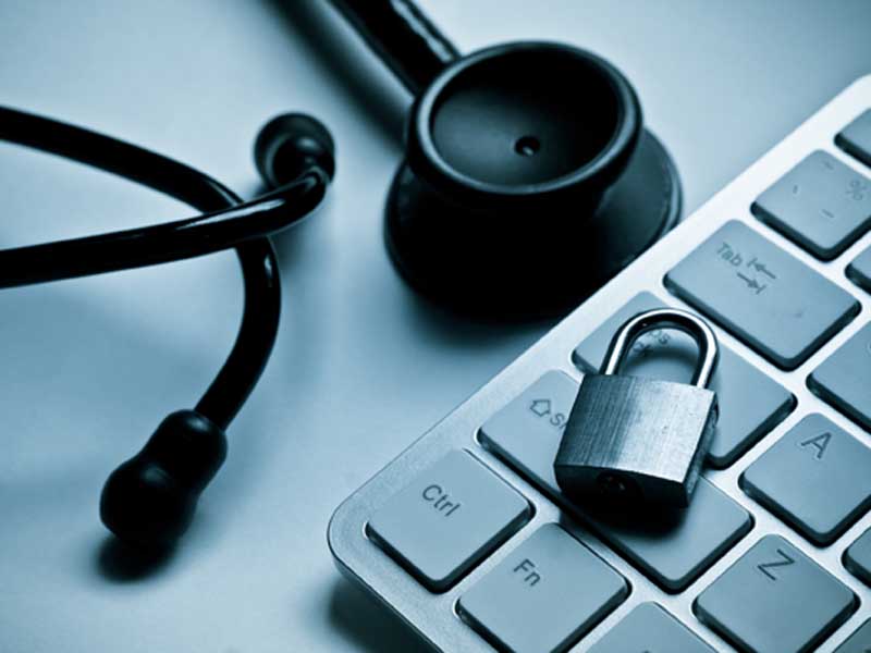 Padlock on a keyboard next to a stethoscope