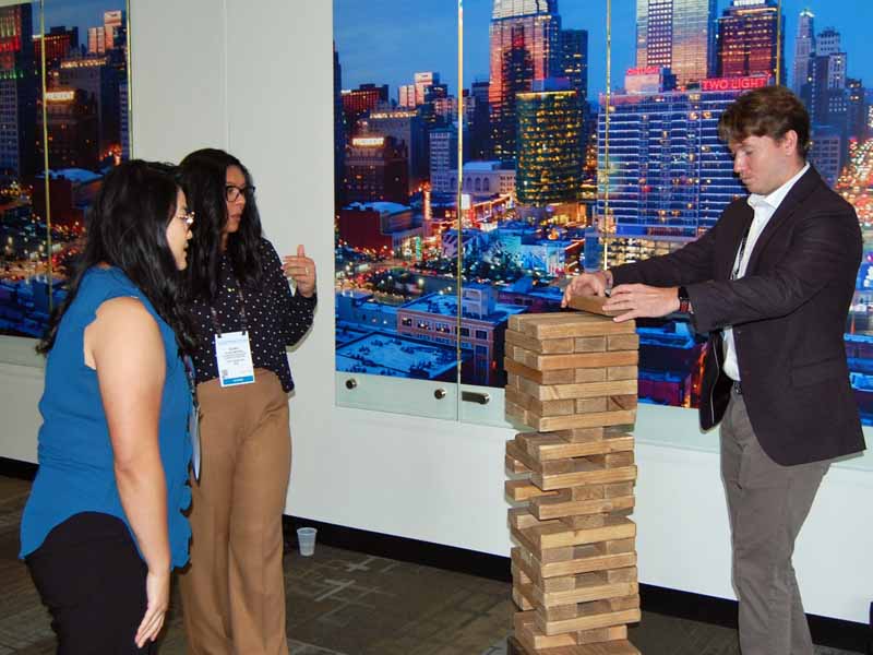 St. George’s University School of Medicine students (from left) Amanda Kwong, Aliah Moore and Brendan Whelan take a break from workshops at National Conference to play a game of Giant Jenga.
