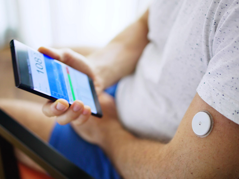 Glucose monitoring tool on patient that is reading results on cellphone. 