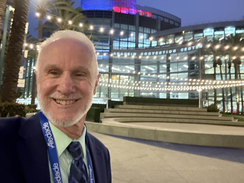 Man in front of lighted convention center